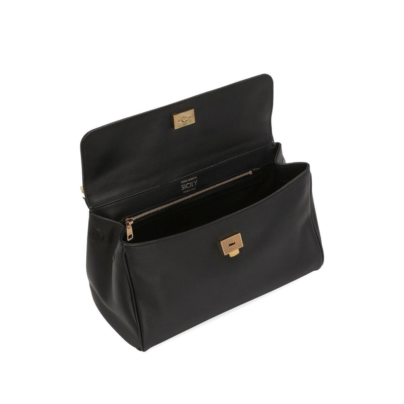 Black handbag with gold accents on a white background
